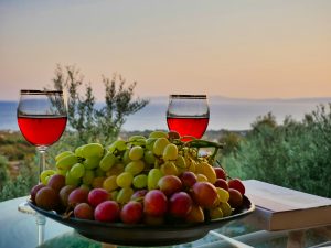 A glass of red wine on a table against an evening sky