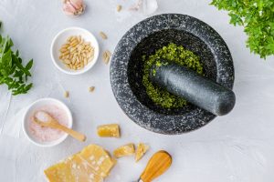 Traditional pesto alla genovese being prepared with basil and pine nuts