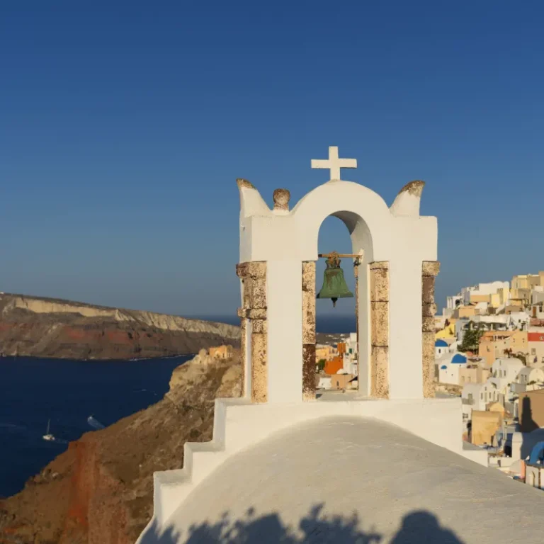 White bell tower and blue domes in Oia, Santorini