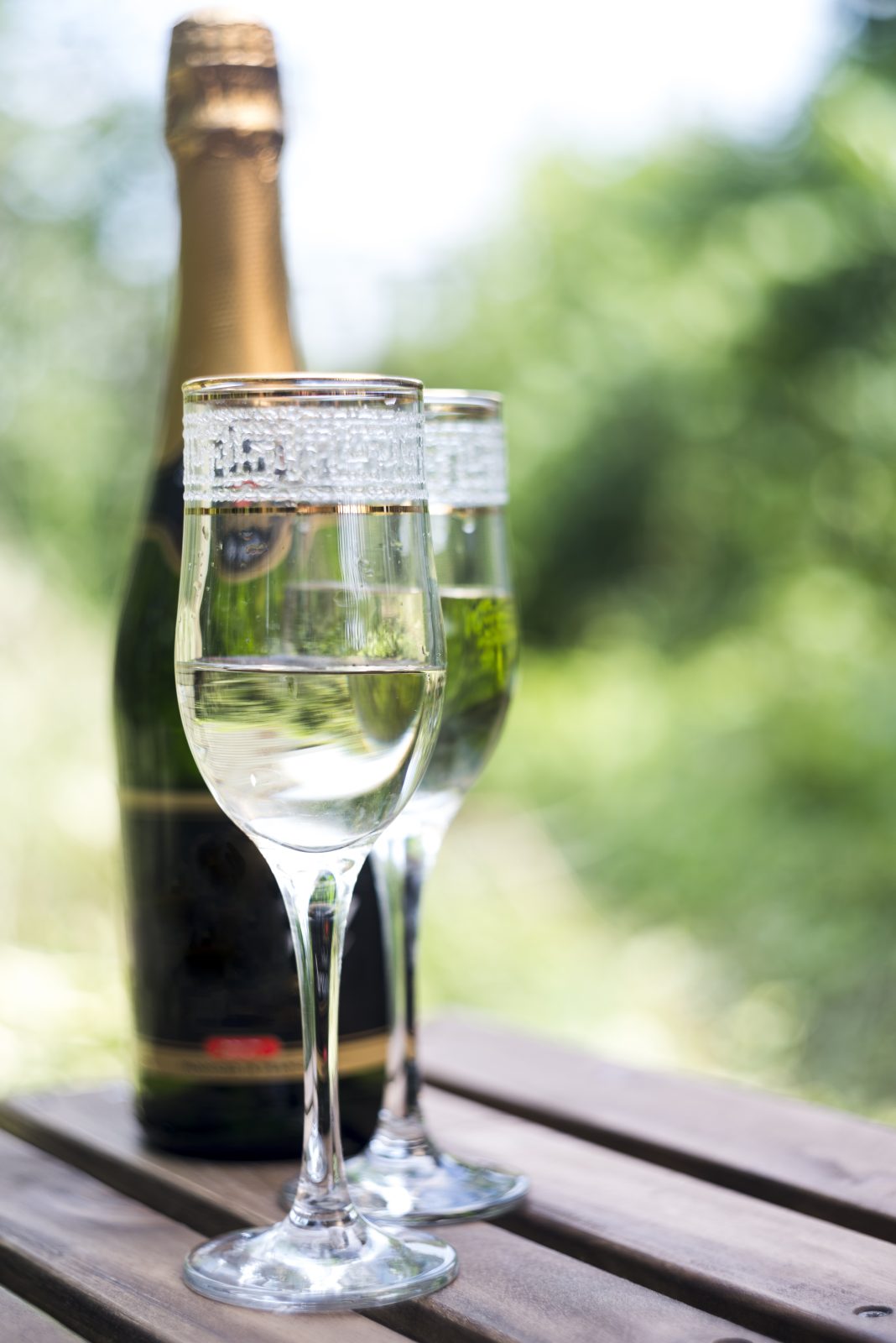 Sparkling wine glasses and bottle on a wooden table, Milan wine tasting