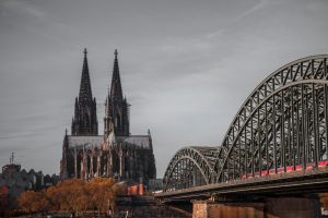 Gothic cathedral towers beside a steel bridge